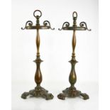 A pair of antique metal fire dogs, bearing residual gilding, with hoop handles and decoratively cast