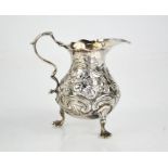 A silver jug embossed with scrollwork, indistinct London hallmarks, initialled I G+A, 2.95toz.