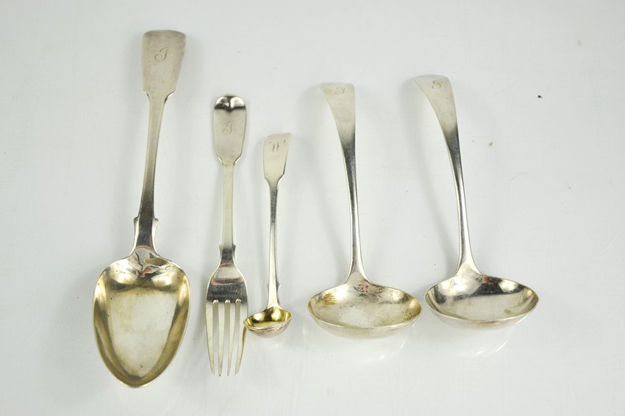 A group of silver to include a Georgian serving spoon, two ladles, fork and sauce spoon, various