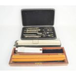 A part-cased set of Lee Guinness technical drawing instruments together with slide rulers, J. Halden