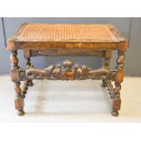 A 19th century oak stool with carved dolphins and a crown and foliage to both fronts, with