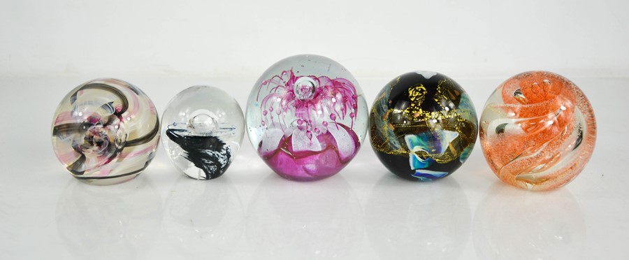 Five glass paperweights of various design, including Caithness examples.