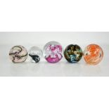 Five glass paperweights of various design, including Caithness examples.