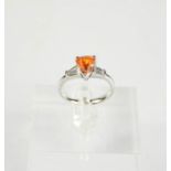 An 18ct gold, orange zircon, and diamond ring, the 2.14ct pear shaped zircon flanked by baguette cut