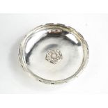 A silver Omar Ramsden dish, tudor rose to the centre, signed to the base Omar Ramsden Me Fecit, 11cm