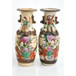 A pair of Chinese vases, painted with figures, and modelled with dogs of fo, 7ins high.