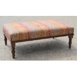 A Victorian mahogany footstool, 102cm wide by 66cm by 37cm high