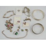 A quantity of silver jewellery including ring, bangles, charm bracelets and other items.