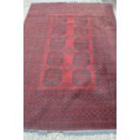 A red ground rug with octagonal patterns to centre, 164cm by 240cm