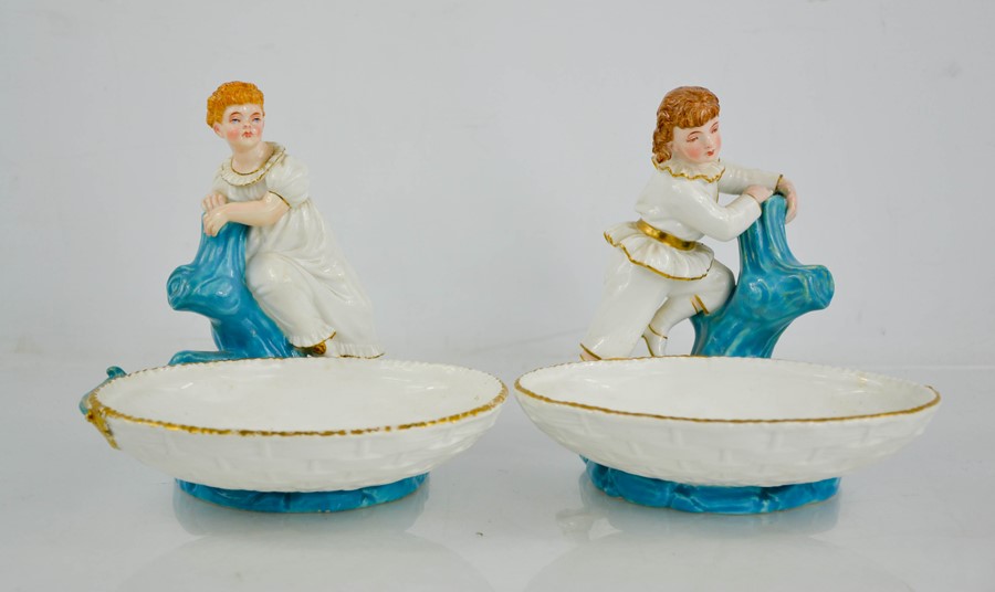 A pair of Royal Worcester dishes, in the form of baskets, with girl and boy modelled standing on