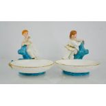 A pair of Royal Worcester dishes, in the form of baskets, with girl and boy modelled standing on