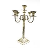 A silver candleabra-candlestick, with five Corinthian column form candle sockets, four scroll