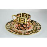 A Royal Crown Derby cup and saucer trio in the Imari pattern.