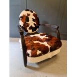 Andrew Martin armchair upholstered in cow hide, with wooden frame and oval back.