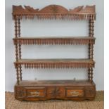 A 19th century Tramp art wall shelf, the shelves divided by turned spindles, the upper edges bearing