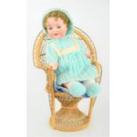 An Armand Marseille bisque doll No 996 and a wicker chair
