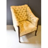 A 19th century button back armchair, upholstered in cream, with a mahogany frame.