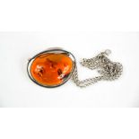 A silver and amber pendant necklace, the amber measures 4½cm long.