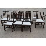 A set of twelve dining chairs including two carvers, with drop in seats, stamped.