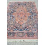 A pink ground wool rug with floral border, 170cm by 240cm