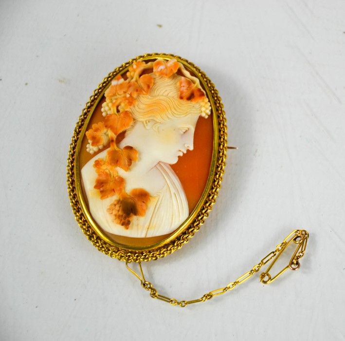 A 15ct gold cameo brooch, depicting a female profile portrait, grape and vine, in a 15ct gold brooch