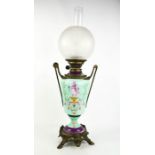 A 19th century porcelain oil lamp painted with classical figures, and flowers, with brass mounted