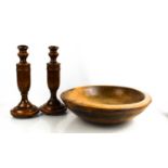 A pair of oak turned candlesticks, together with an early treen bowl.38cm diameter