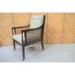 A French Bergere armchair, with caned back and seat and buttoned cushions.