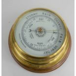 An early 20th century aneroid barometer with brass outer casing, ceramic porcelain dial signed