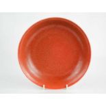 A 20th century Chinese dish, with orange/red pitted glaze, bearing six character marks to the