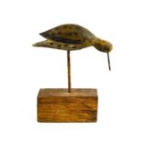 A naive treen carved bird with a beak made from a nail, raised on an oak plinth29cm high