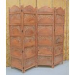 An Indian four panel wooden carved screen, each panel carved and pierced with decorative flowers and