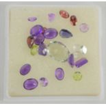 A collection of various gemstones to include garnet, green topaz and amethyst