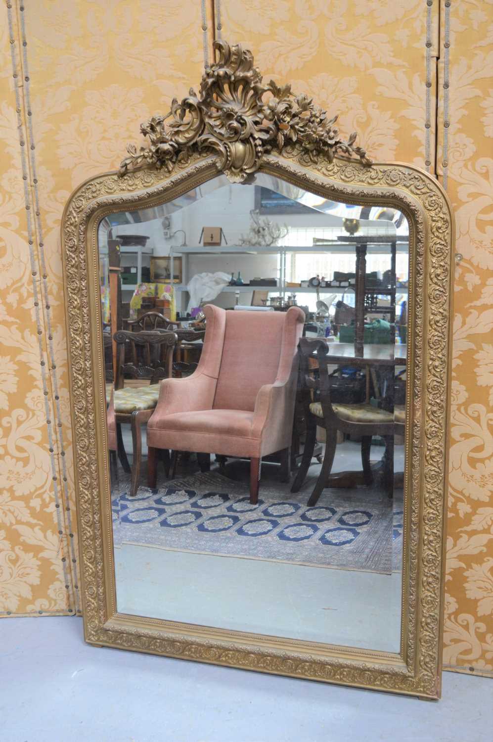 A large late 19th / early 20th century gold painted composition wall mirror with Rococo style