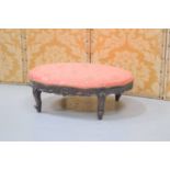 A mahogany carved oval footstool with upholstered top.