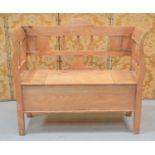 An antique pine window settle, the seat having a hinged lid raised on block feet96cm high by 110cm