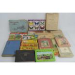 A group of vintage childrens books and cigarette car albums to include Winnie the Pooh, Enid Blyton,