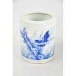 A Chinese 20th century blue and white brush pot, depicting a bird, and bearing calligraphy marks