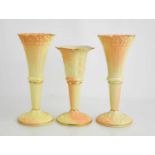 A pair of Locke & Co Worcester porcelain blush ivory bud vases and a single example, all of fluted