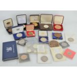 A group of commemorative coins and medallions to include John F Kennedy, Isle of Man five pounds,