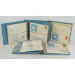 Three albums of United Nations silver medallic first day covers and two silver peace medals
