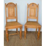 A pair of 20th century gothic style pine hall chairs109cm