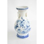 A Chinese blue and white baluster form vase, deorated with flowers and having ring handles, 19cm