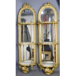 A pair of giltwood wall sconces, in three tiers with mirrored back, giltwood composition carved