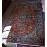 An early 20th century Middle Eastern orange ground rug decorated with floral motifs with blue