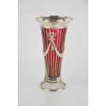 A silver and cranberry glass bud vase, the openworked silver vase, decorated with swags and bows,