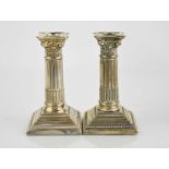 A pair of silver candlesticks in the form of Corinthian columns, with weighted bases.12cm high.