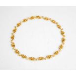 An 18ct gold necklace, composed of graduated fleur de lys form links, stamped 750, 20.5g.40cm