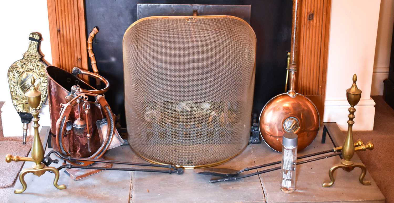 A quantity of antique copper and brass ware to include warming pan, coal scuttle, andirons and