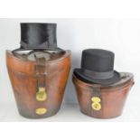 Two 19th century top hat boxes with original straps and containing top hats one made by Woodrow